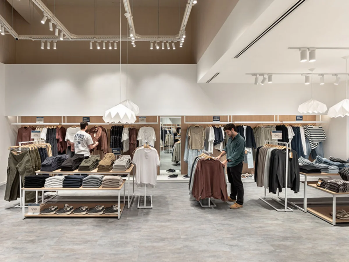 BAS Nuevo Centro - Retail merchandising display with organized folded apparel and wood flooring - Contract Workplaces.webp
